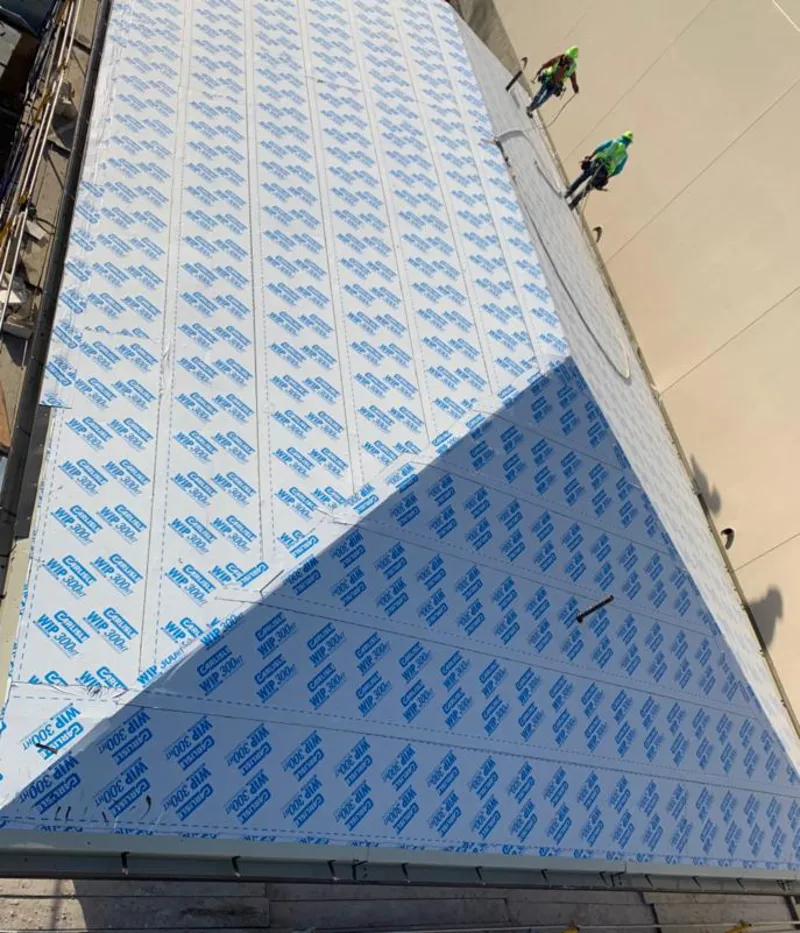 Professional roofers installing underlayment on a metal roof in Costa Mesa